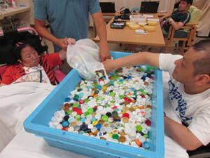 みんなで集めたキャップをお湯と洗剤で洗っています。