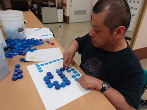 文字「WELCOM TO AKASHIA NO MORI」の文字を貼付けていきます。白・赤・緑のキャップのみで文字を作成しています。